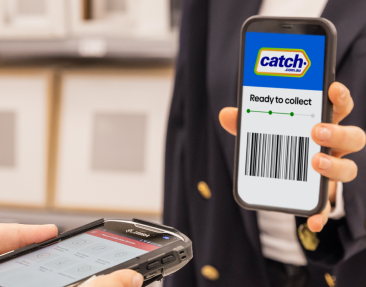 Person holding a mobile device with barcode scanner indicating Catch order is Ready to Collect. A second person is holding a device to scan the barcode